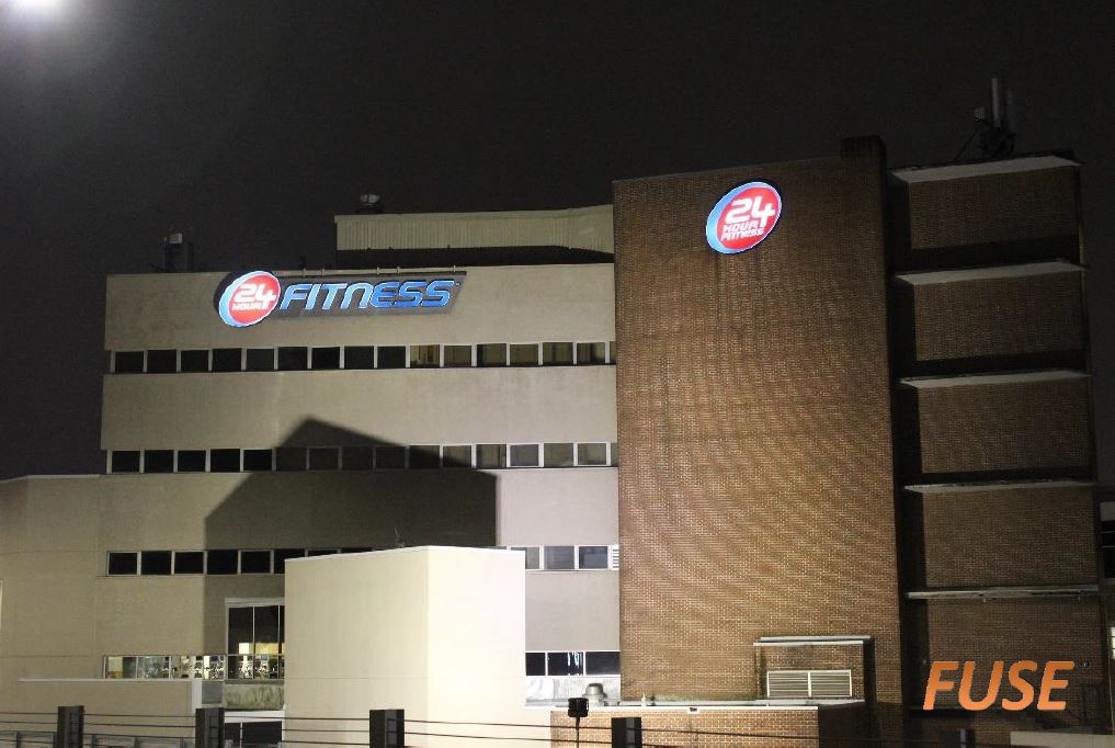 A large building with the word fitness on it at night