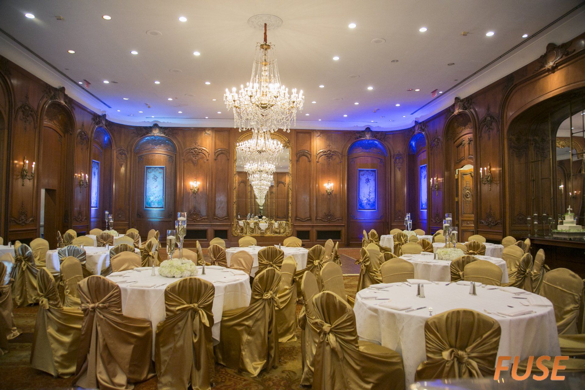 A large room with tables and chairs and a chandelier.