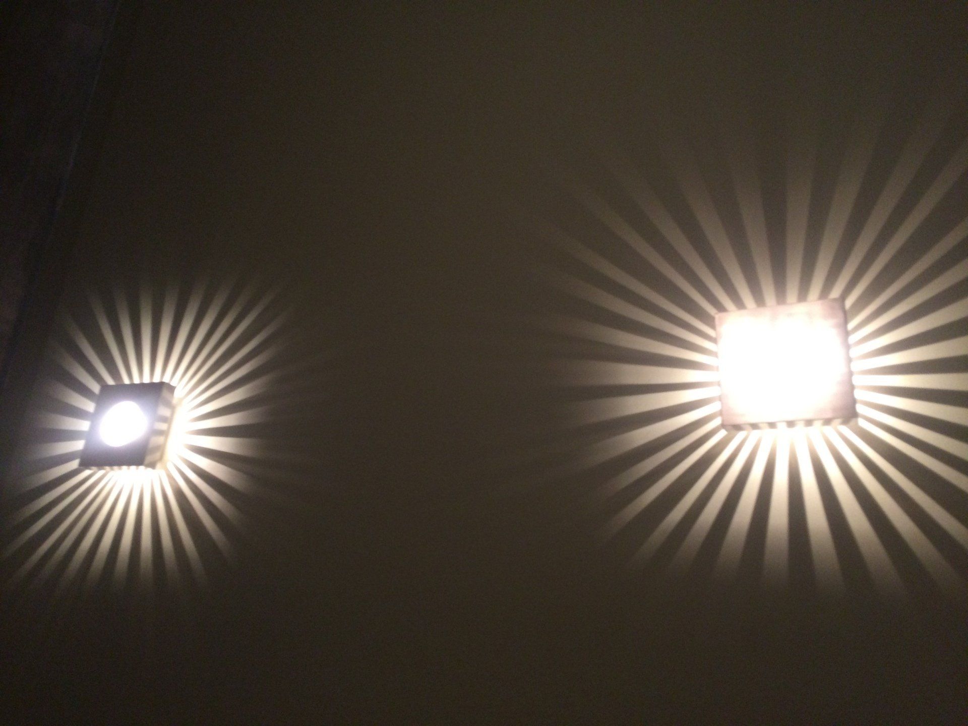 Two lights are shining on a dark wall