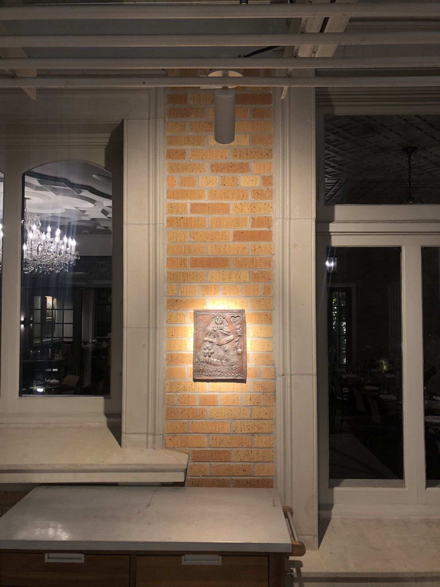 A painting is hanging on a brick wall in a room