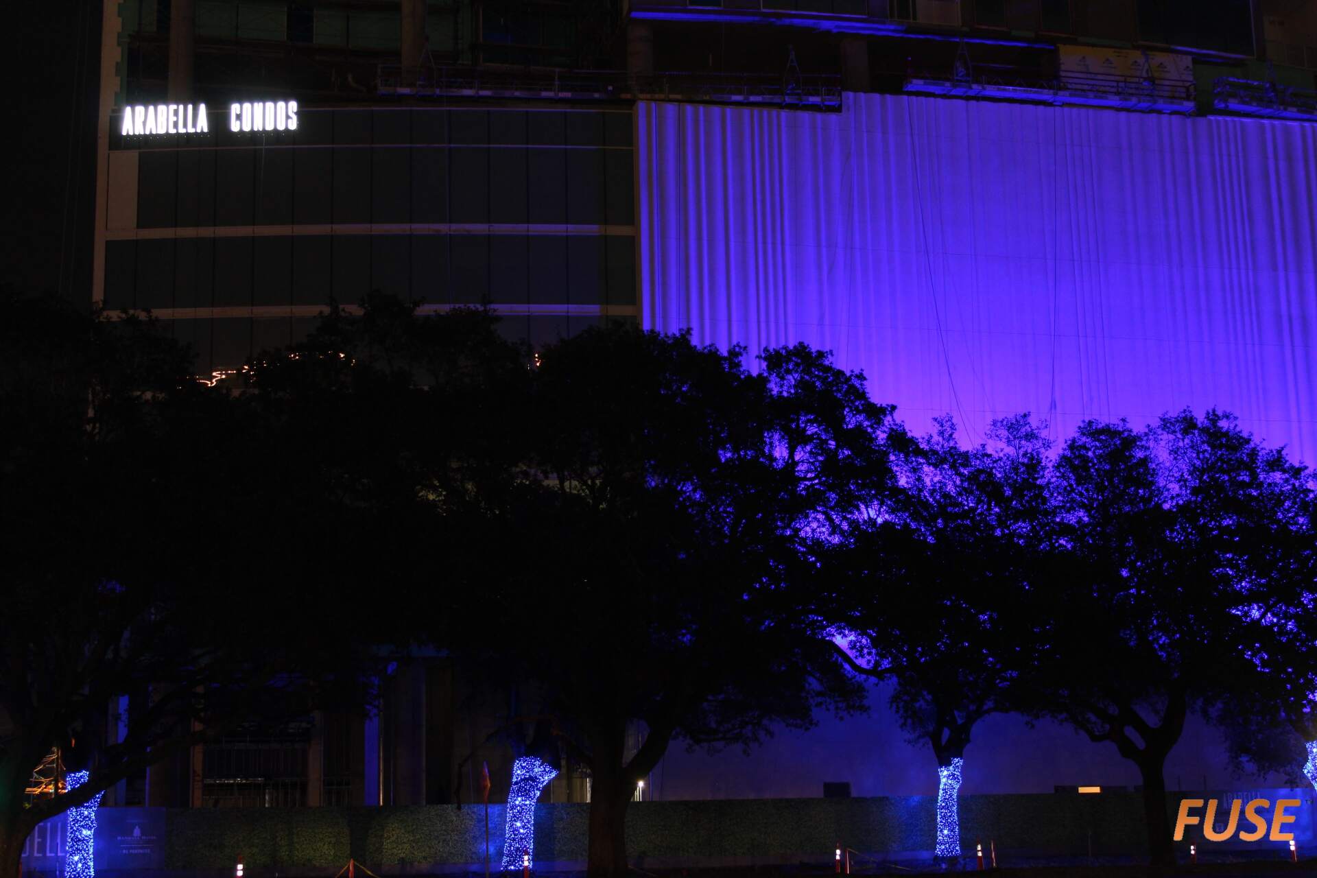A building with purple lights on it is lit up at night.