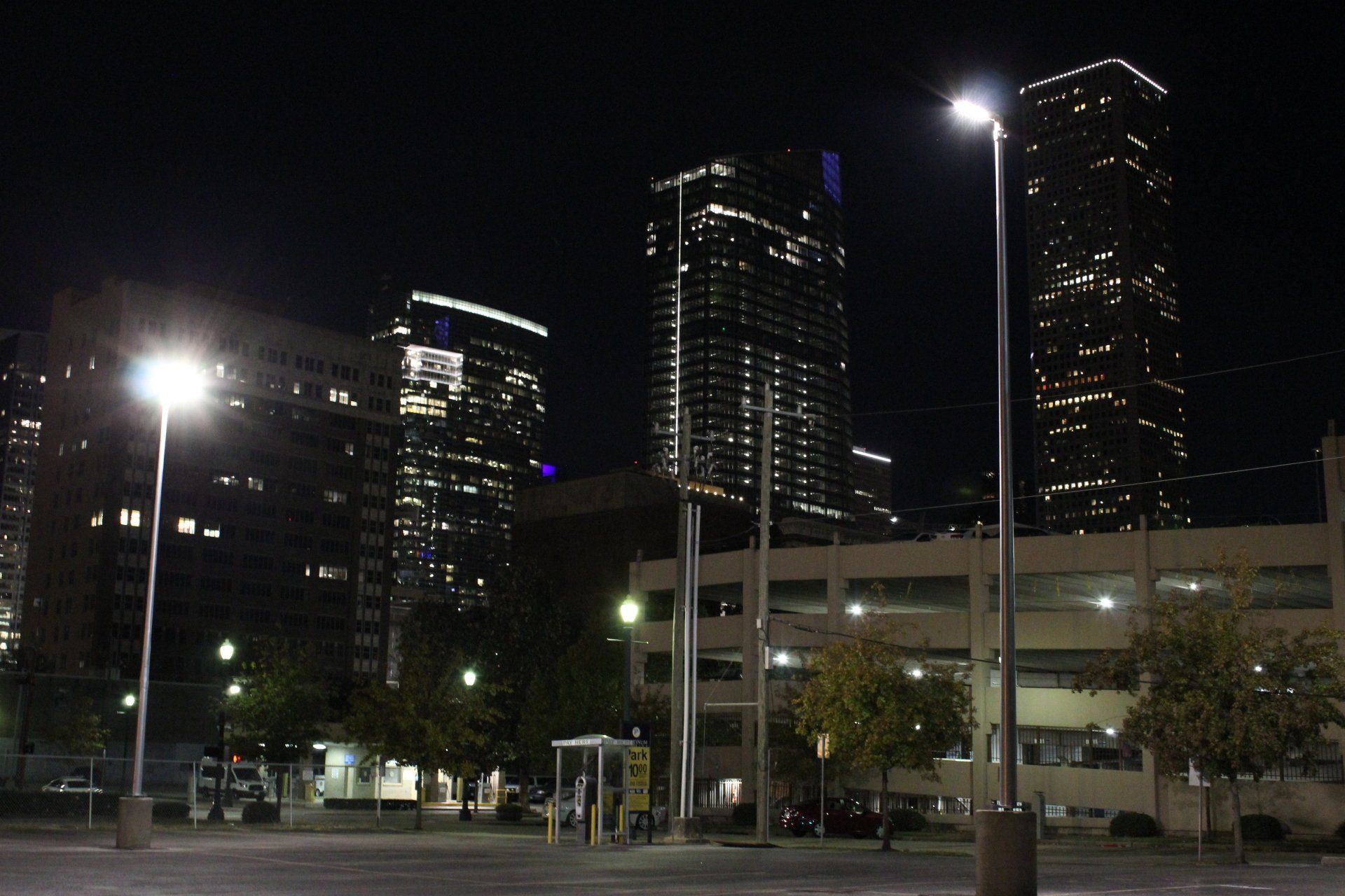 A parking lot in front of a city skyline at night