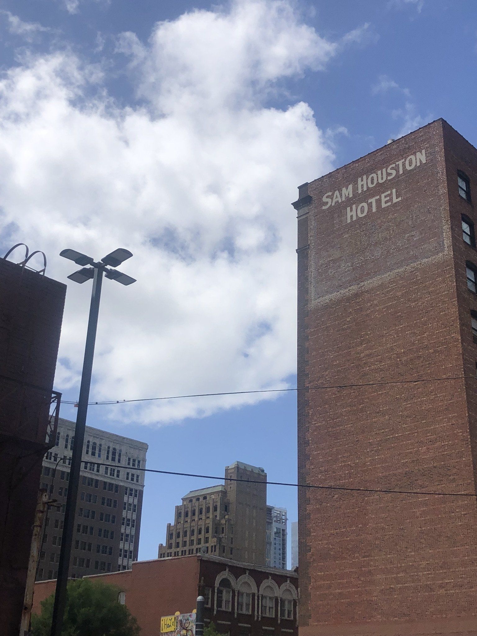 A tall brick building with the name sam houston hotel on it