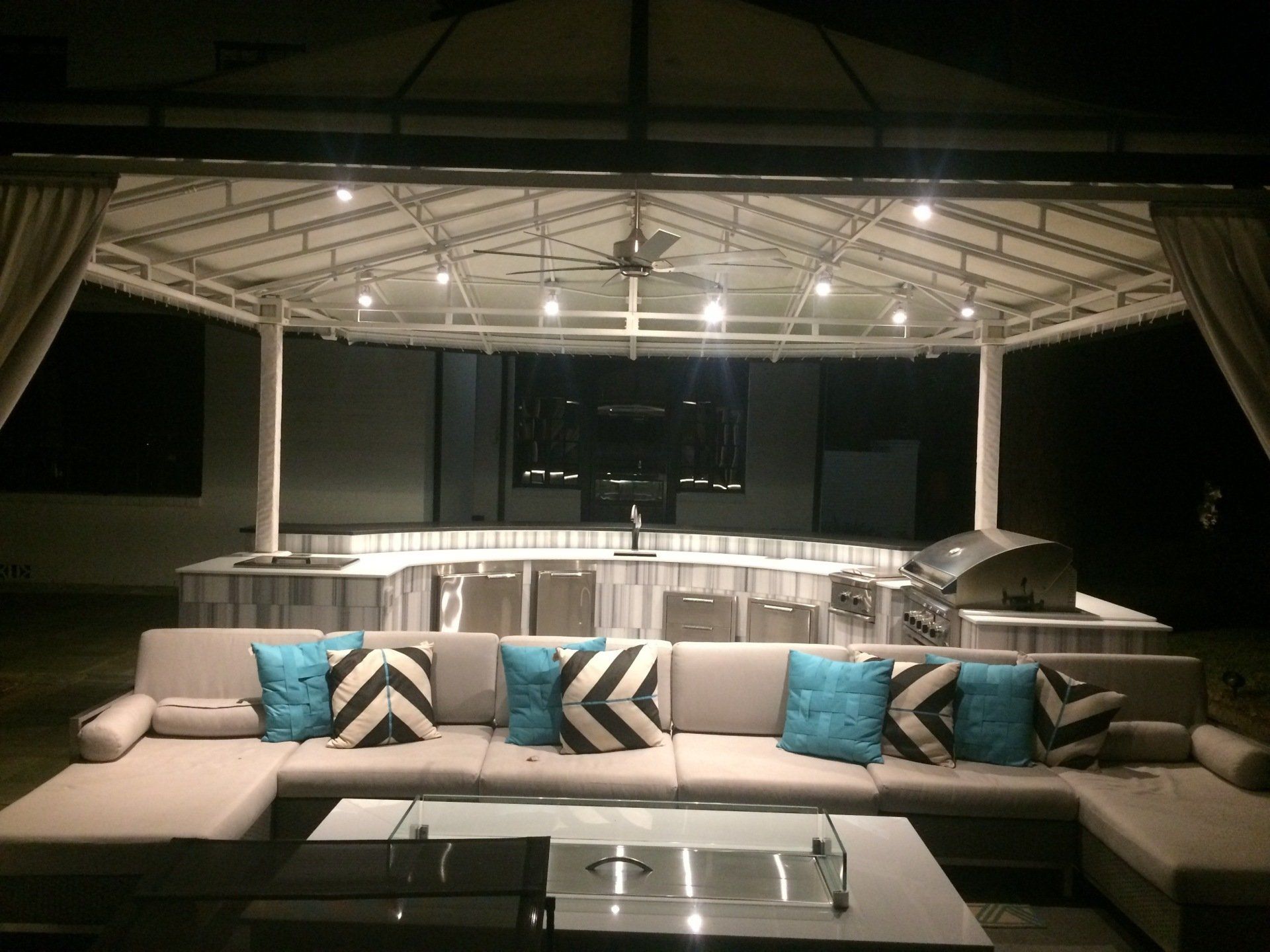 A patio area with a couch and a table at night