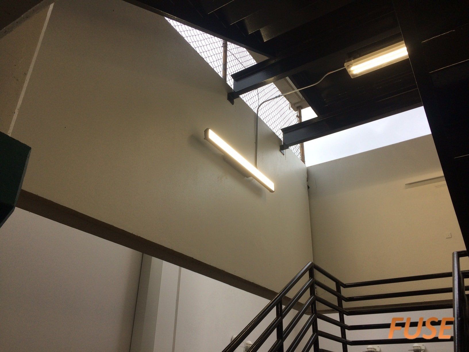 Looking up at a staircase with a light hanging from the ceiling