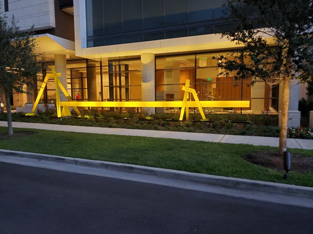 A large building with a yellow sculpture in front of it