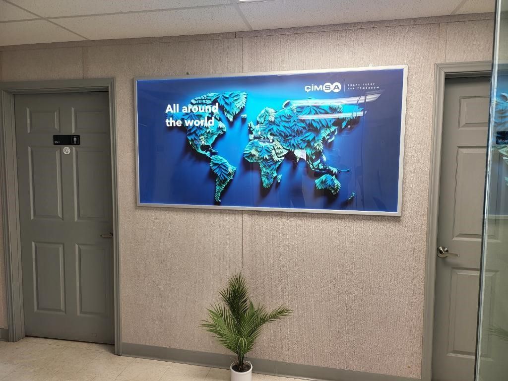 A picture of a map of the world is hanging on a wall