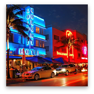 Cars are parked in front of a hotel at night