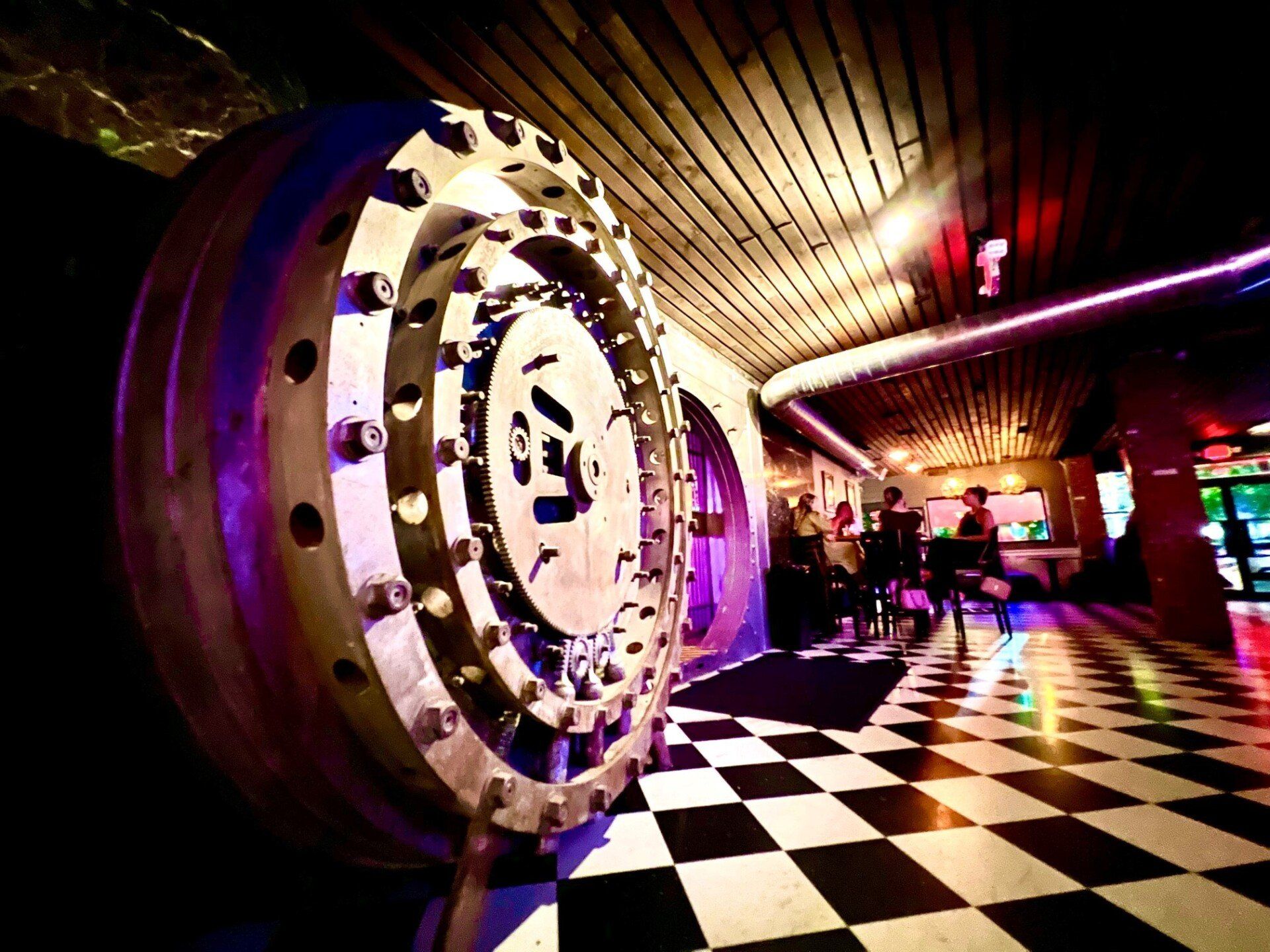 A vault door in a room with a checkered floor