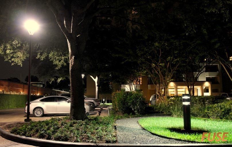 A white car is parked in a parking lot at night