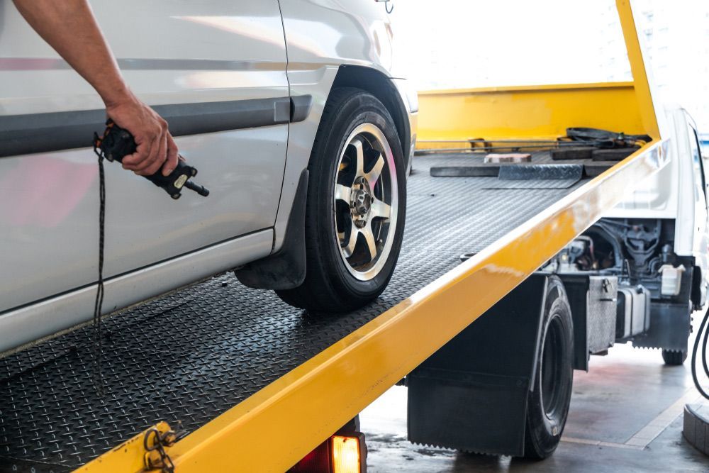 A Car Is Being Towed by A Tow Truck — Rasmussen Mechanical & Tyres in Garbutt, QLD