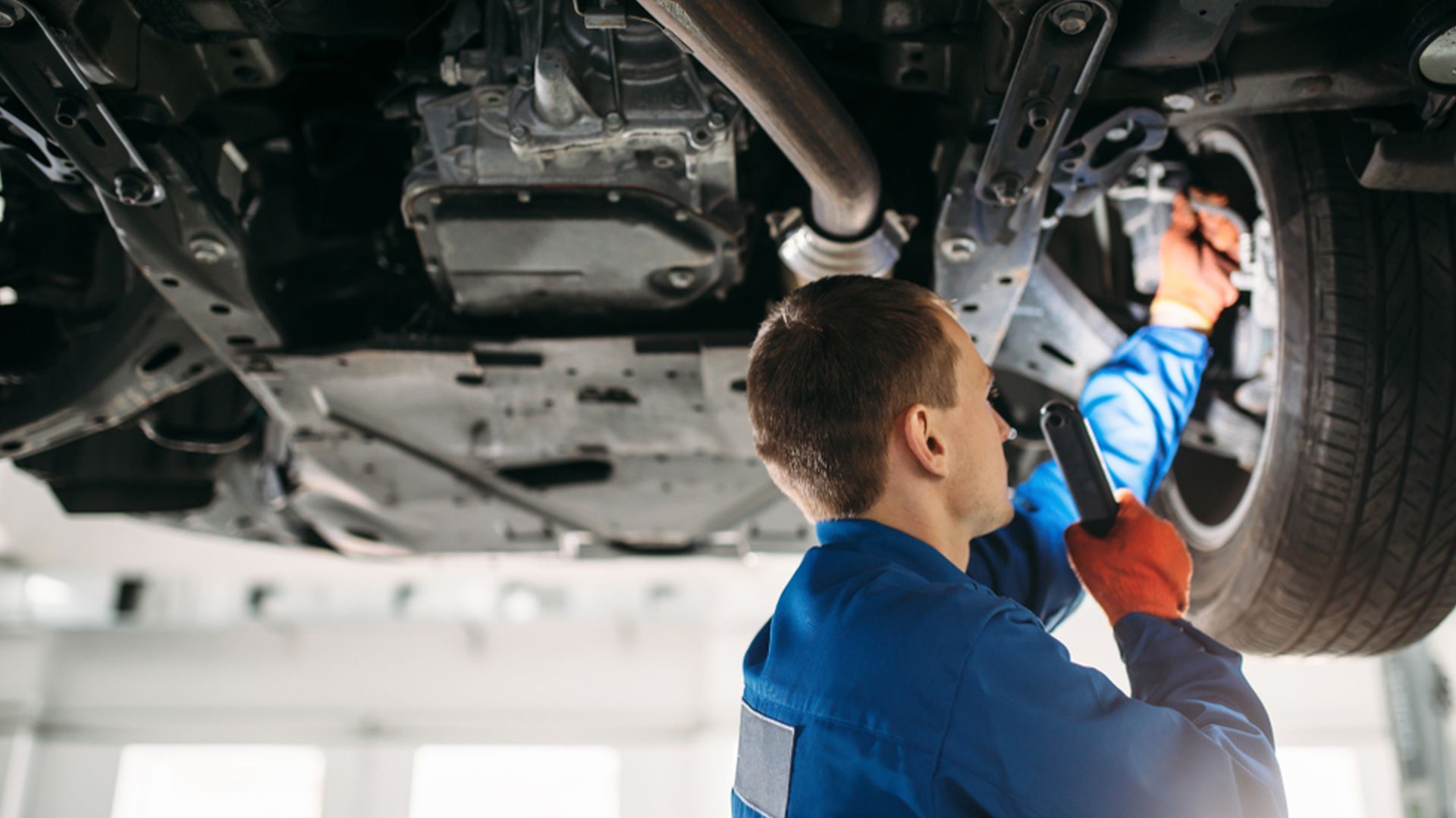 A Mechanic Is Writing on A Clipboard Under the Hood of A Car — Rasmussen Mechanical & Tyres in Garbutt, QLD