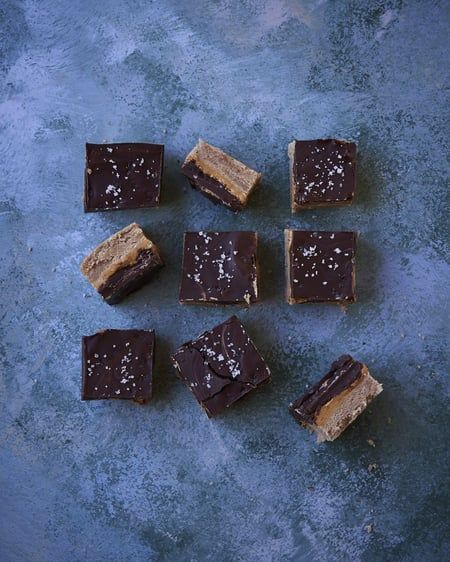 A bunch of chocolate and peanut butter bars are sitting on a table.