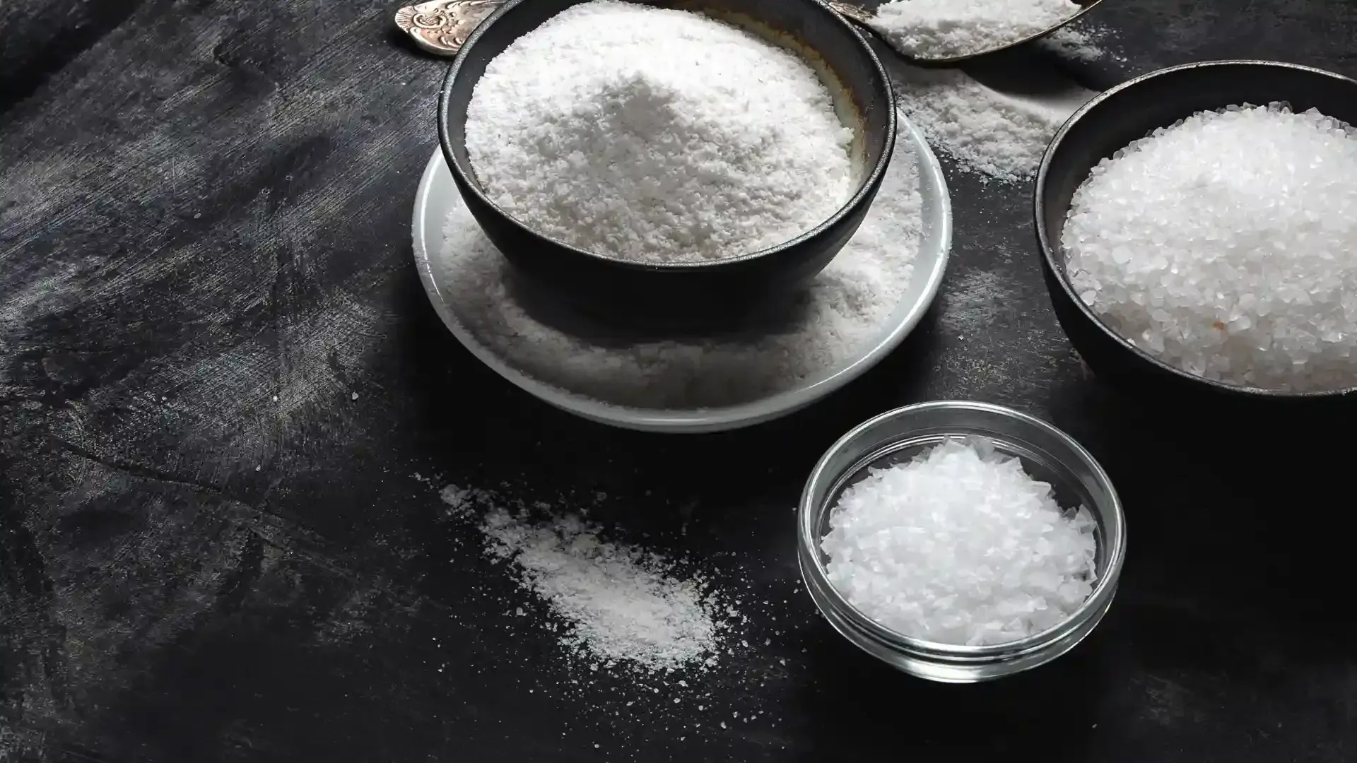 Three bowls of salt are sitting on a table.