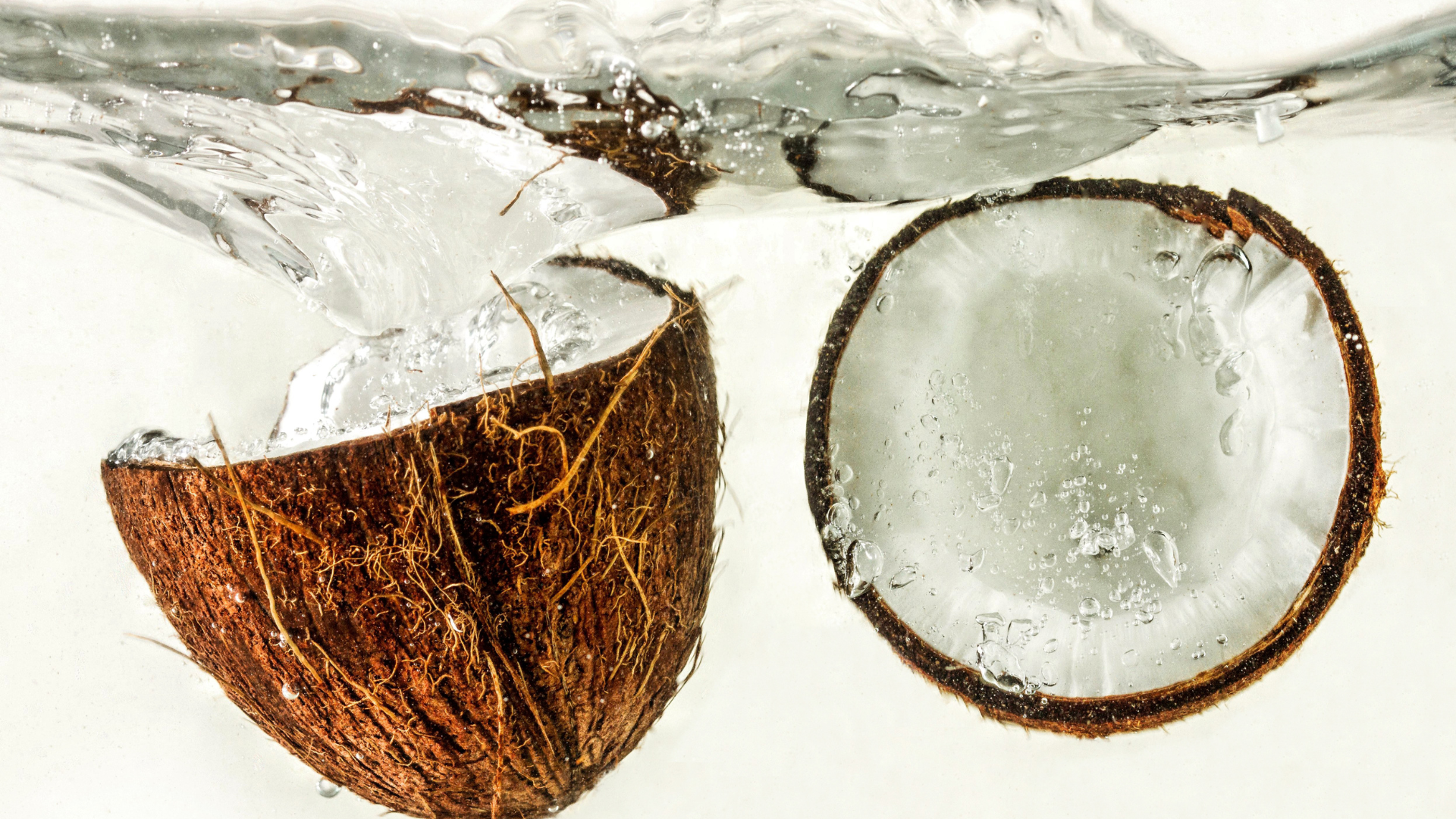 A coconut is being splashed into a pool of water.