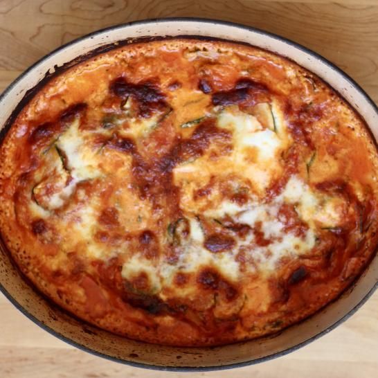 A pizza in a pan on a wooden table