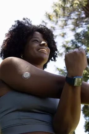 A woman with a patch on her arm is stretching her arms.