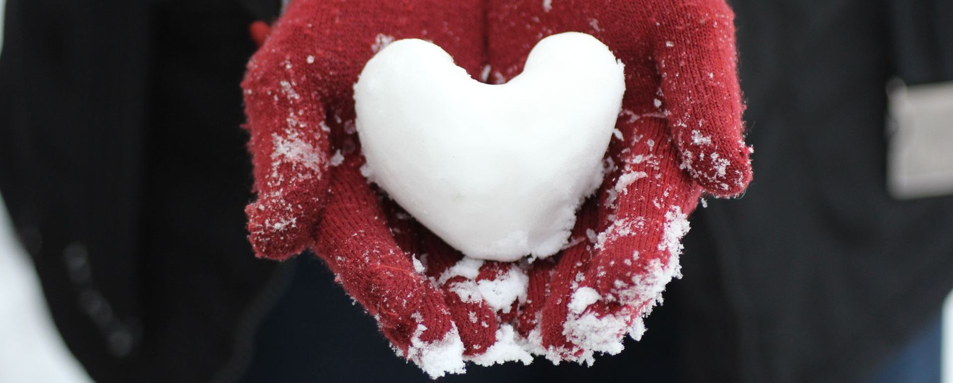 hands holding snow heart