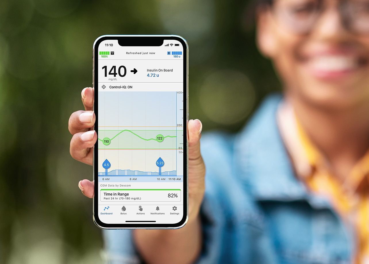 A woman is holding a cell phone with a graph on it.