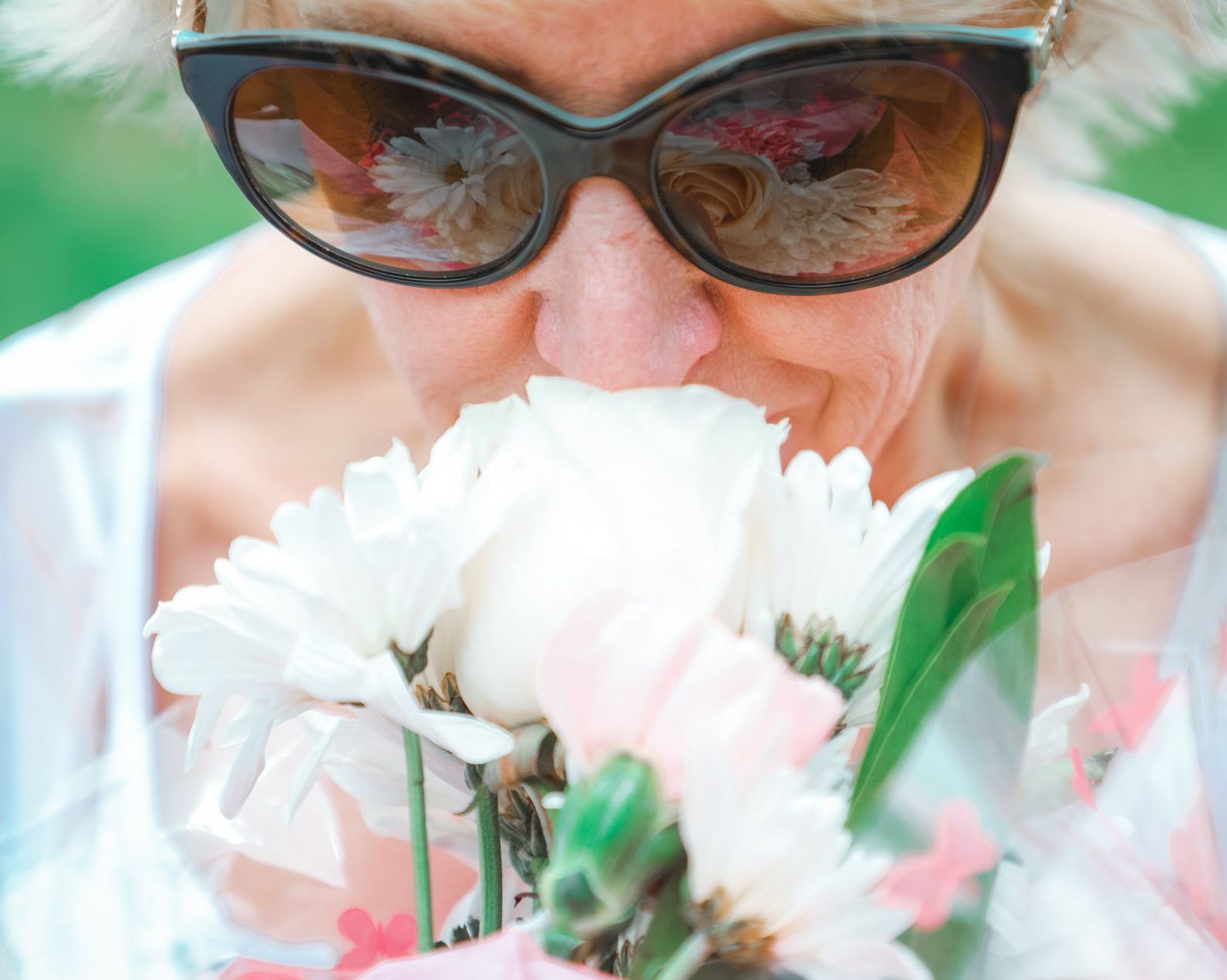 older woman smelling flowers