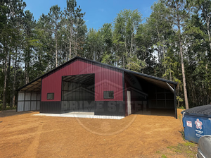 A red barn is sitting in the middle of a grassy field.