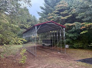A blue carport is sitting in the middle of a grassy field.