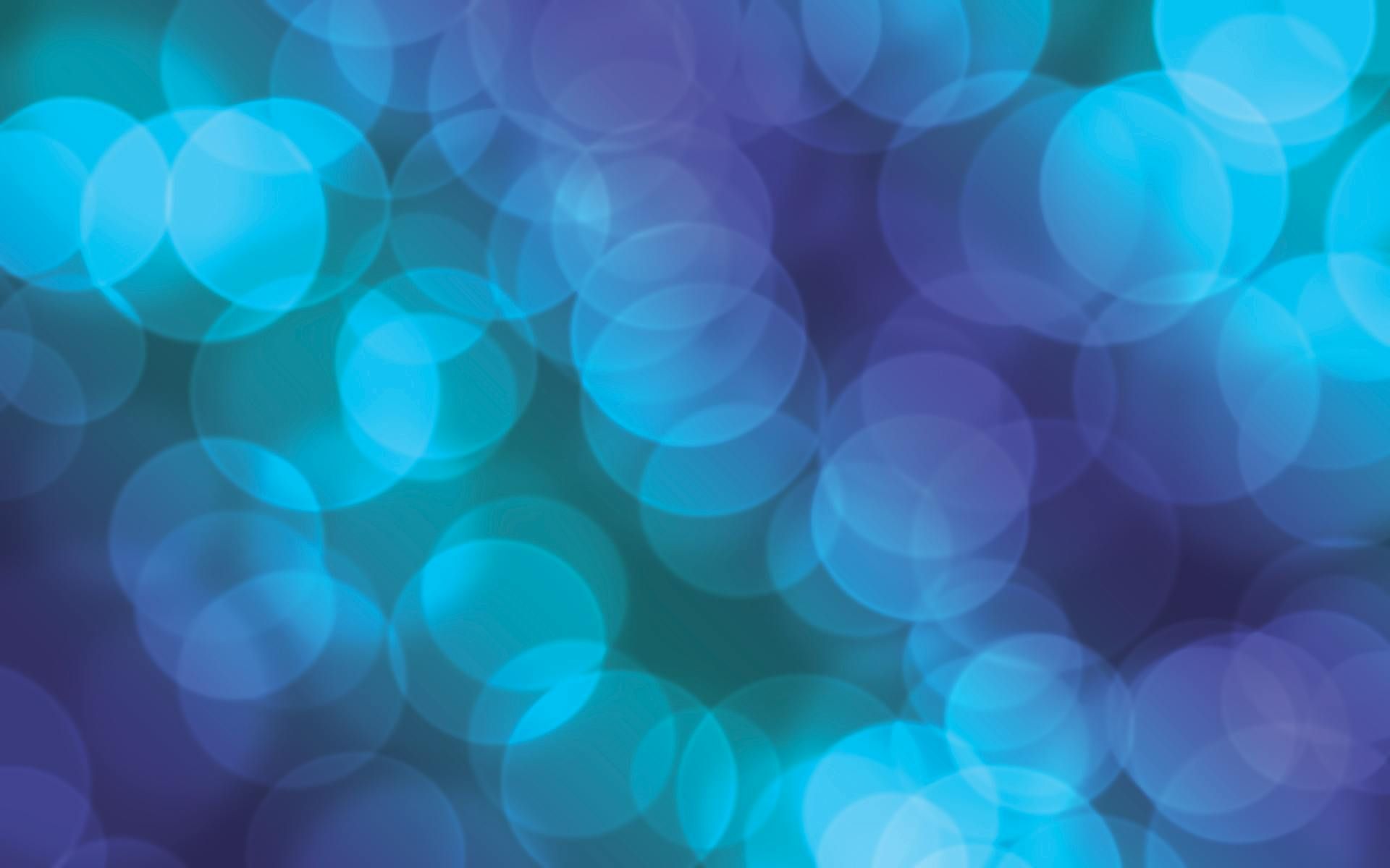 A blurry picture of blue and purple lights on a purple background.