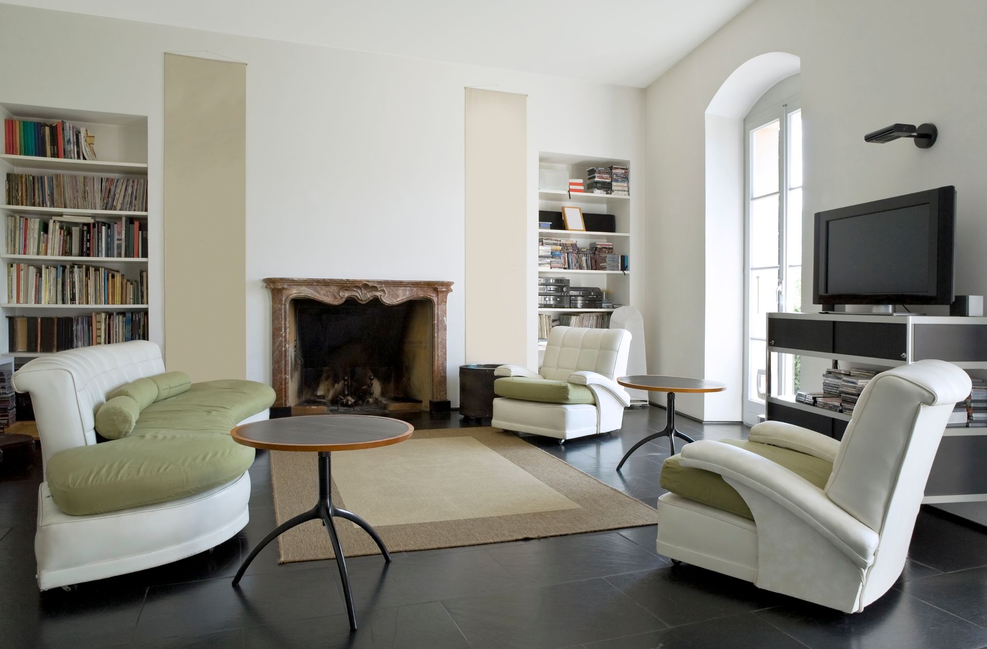 A living room with pink walls and a picture of a cat on the wall.