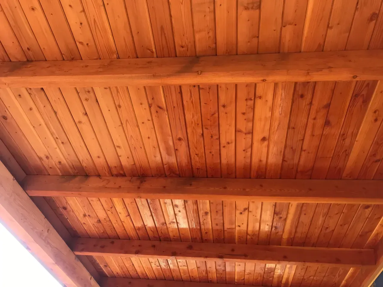 A close up of a wooden ceiling with beams