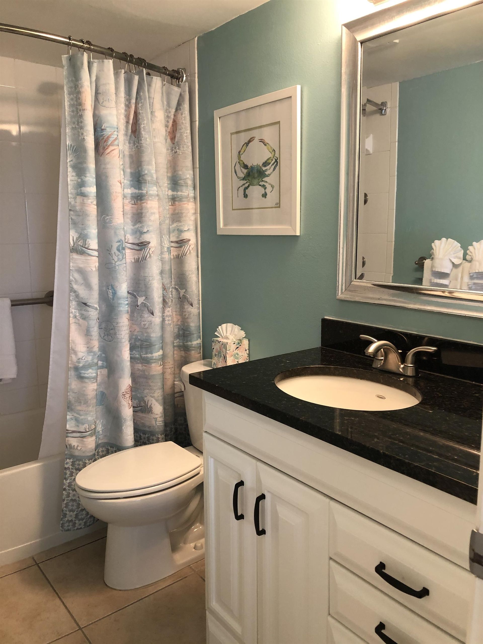 A bathroom with a toilet a sink and a mirror