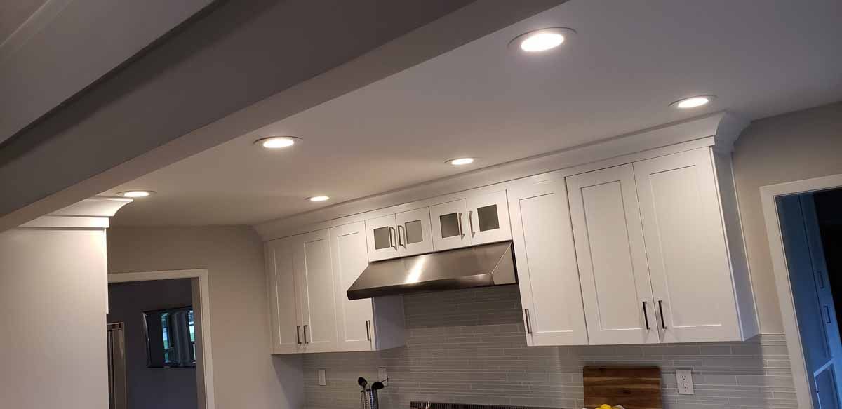 A kitchen with white cabinets and a stove top oven.