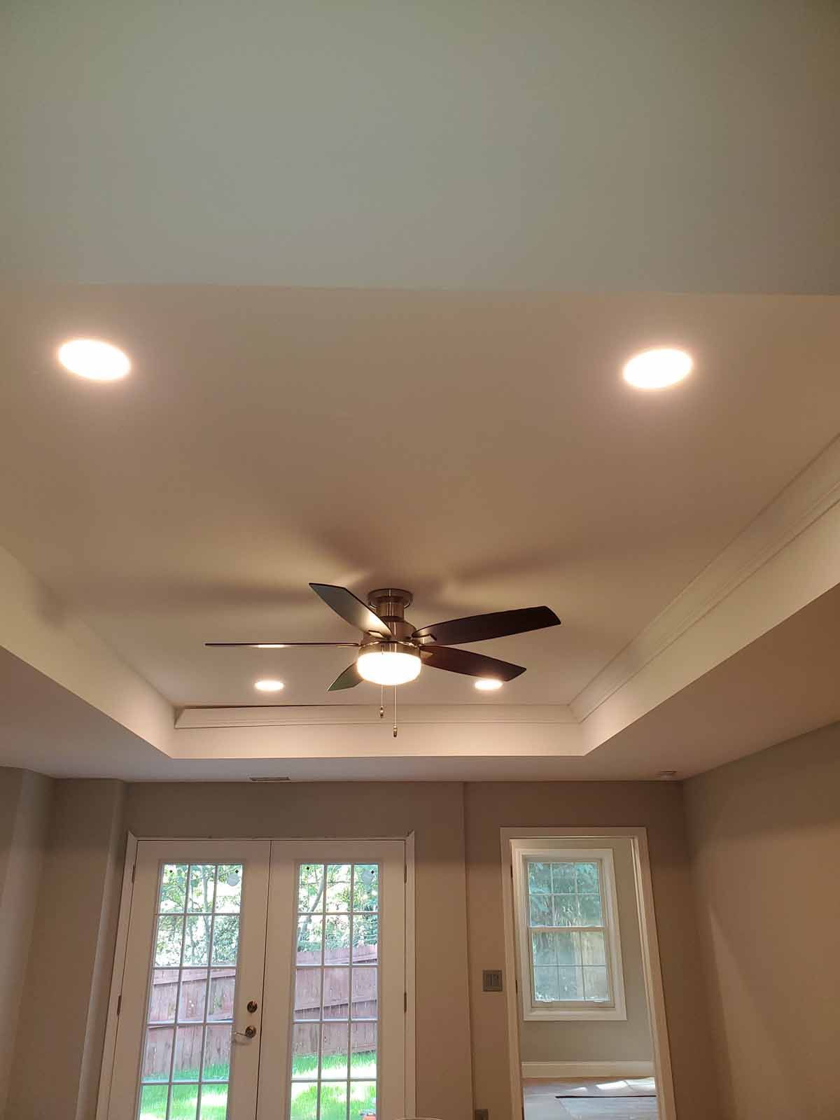 A ceiling fan is hanging from the ceiling of a room.