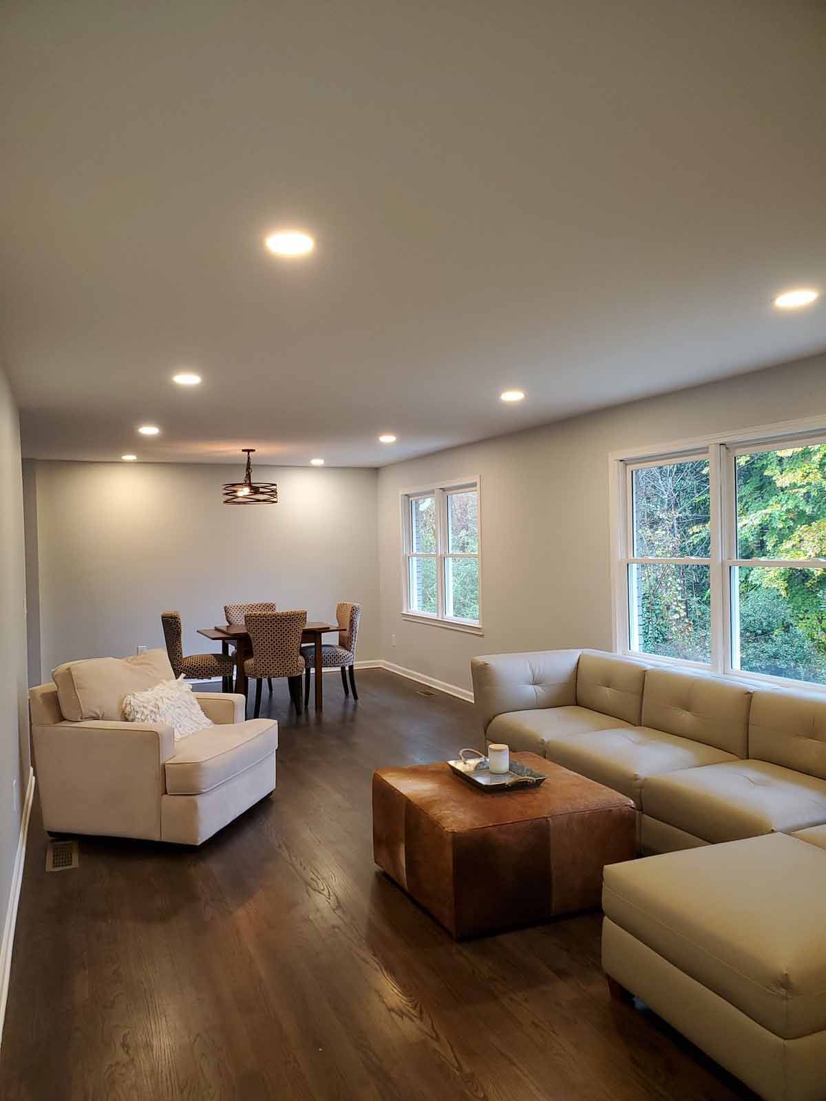 A living room with a couch , chair , table and ottoman.
