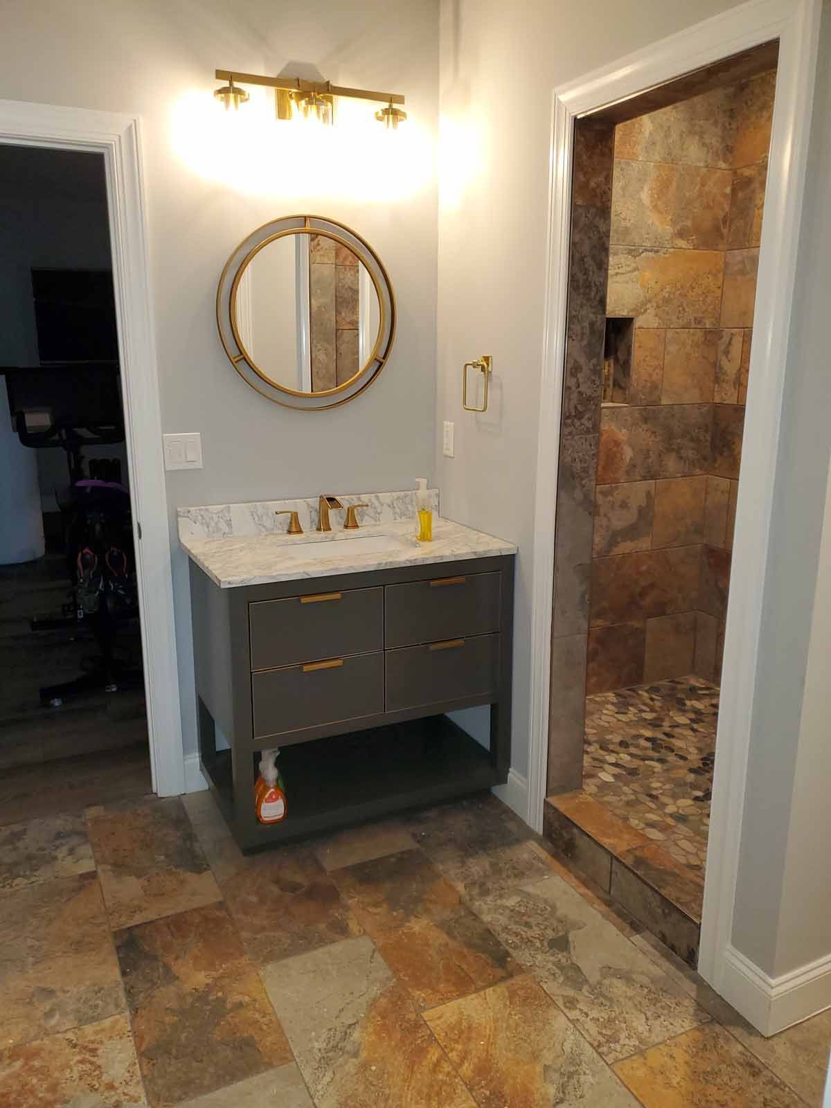 A bathroom with a sink , mirror , and walk in shower.