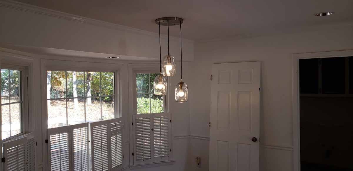 A room with a lot of windows and lights hanging from the ceiling.