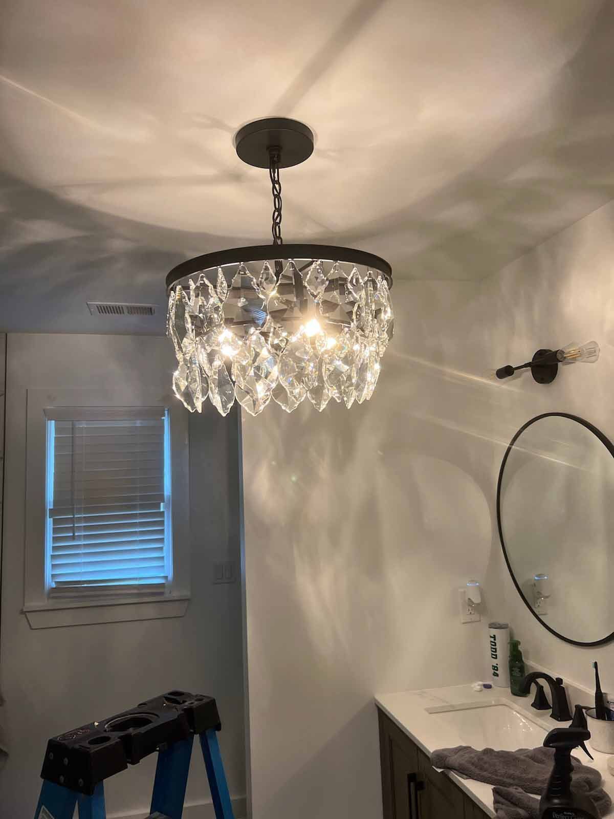 A bathroom with a chandelier hanging from the ceiling.