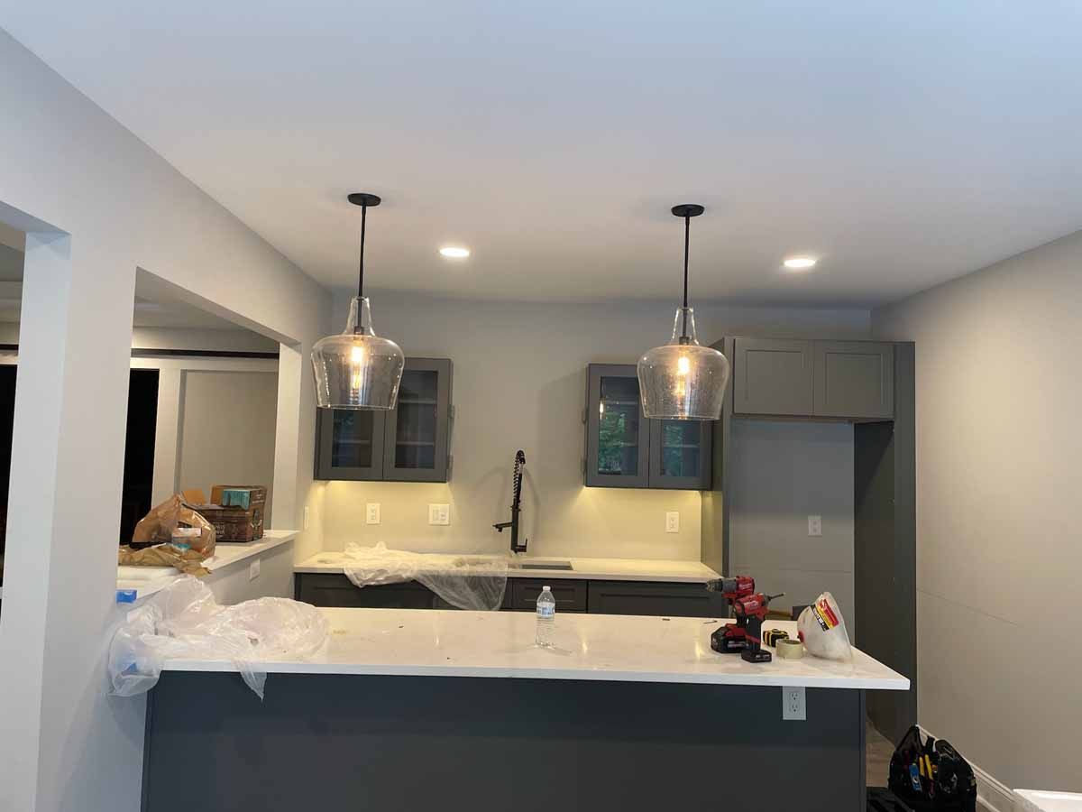 A kitchen under construction with two pendant lights hanging from the ceiling.