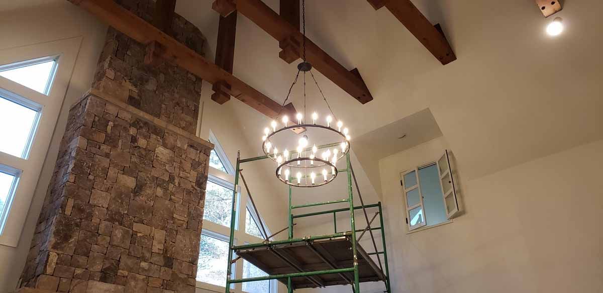 A large room with a fireplace and a chandelier hanging from the ceiling.