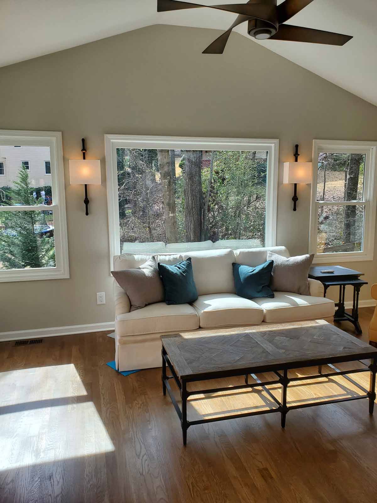 A living room with a couch , coffee table , and ceiling fan.