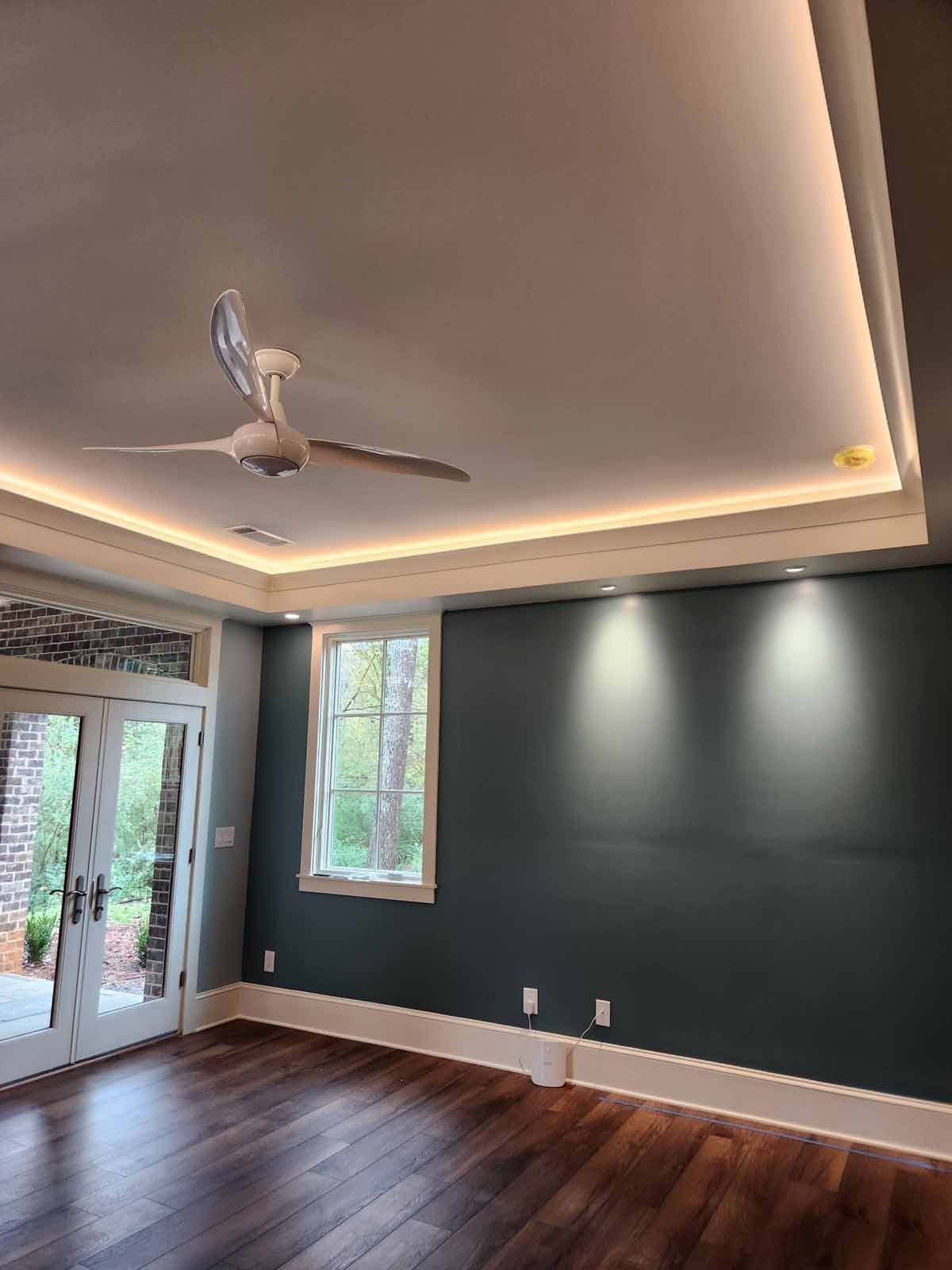 A living room with hardwood floors and a ceiling fan.