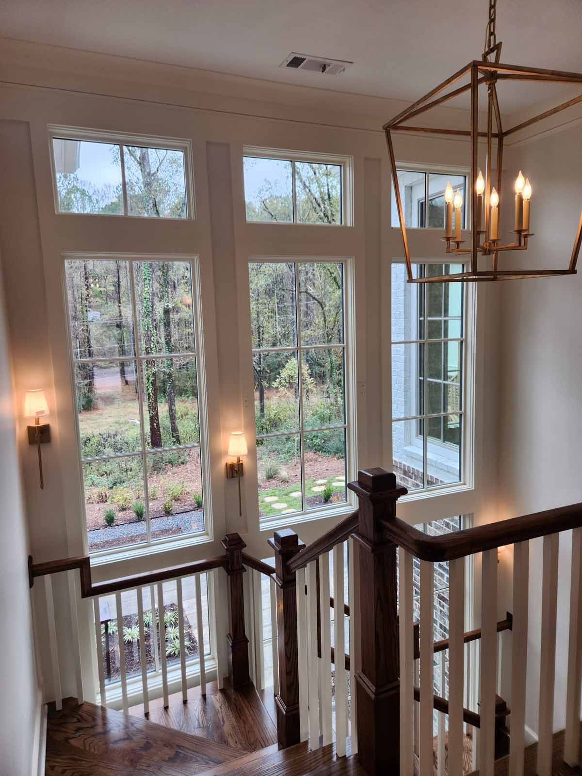 A staircase with lots of windows and a chandelier hanging from the ceiling.