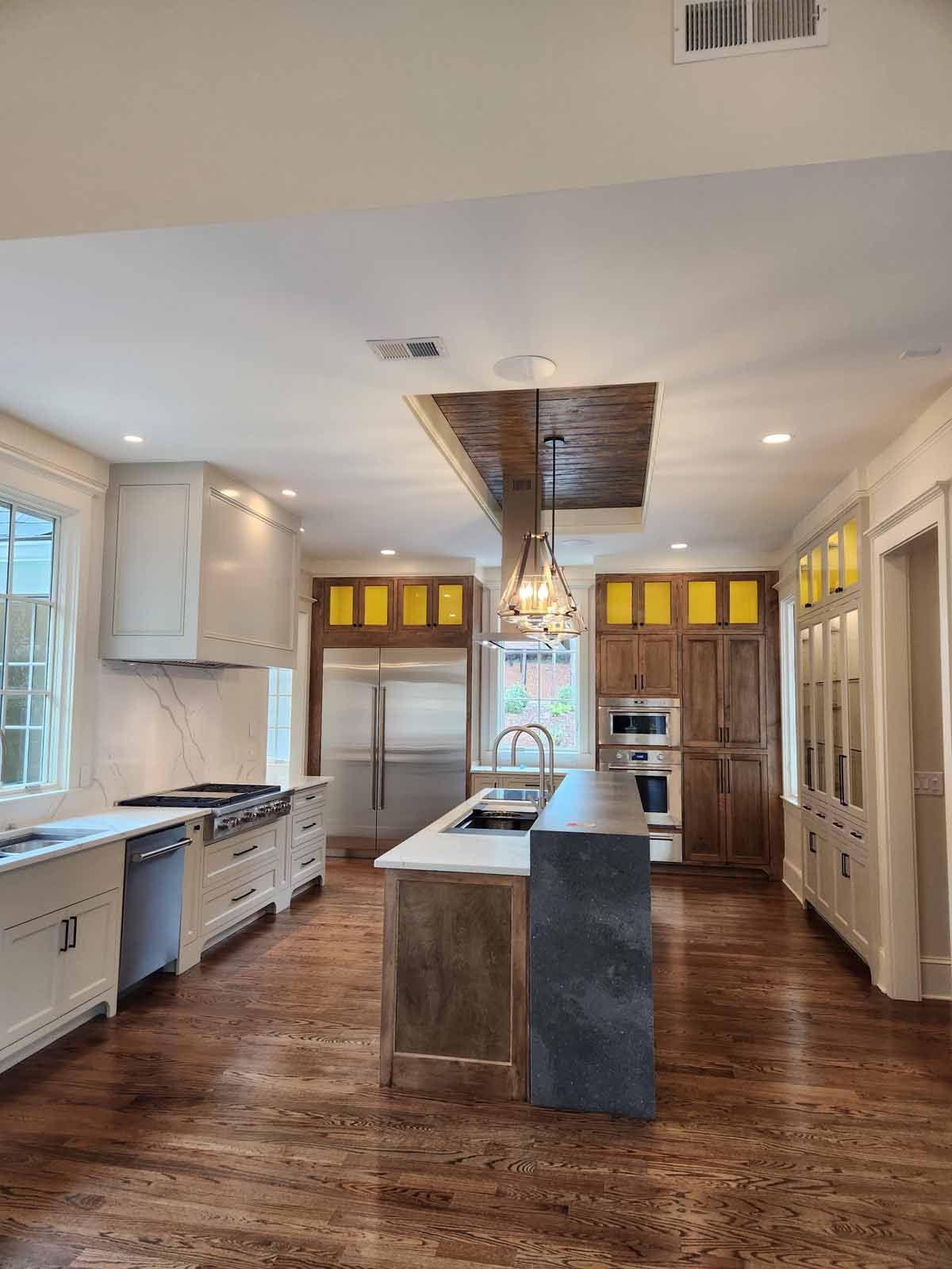 A large kitchen with stainless steel appliances and wooden floors.
