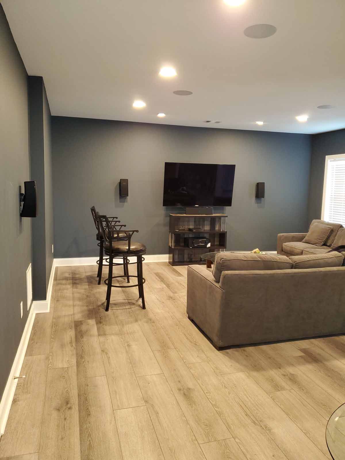 A living room with a couch , chairs and a flat screen tv.