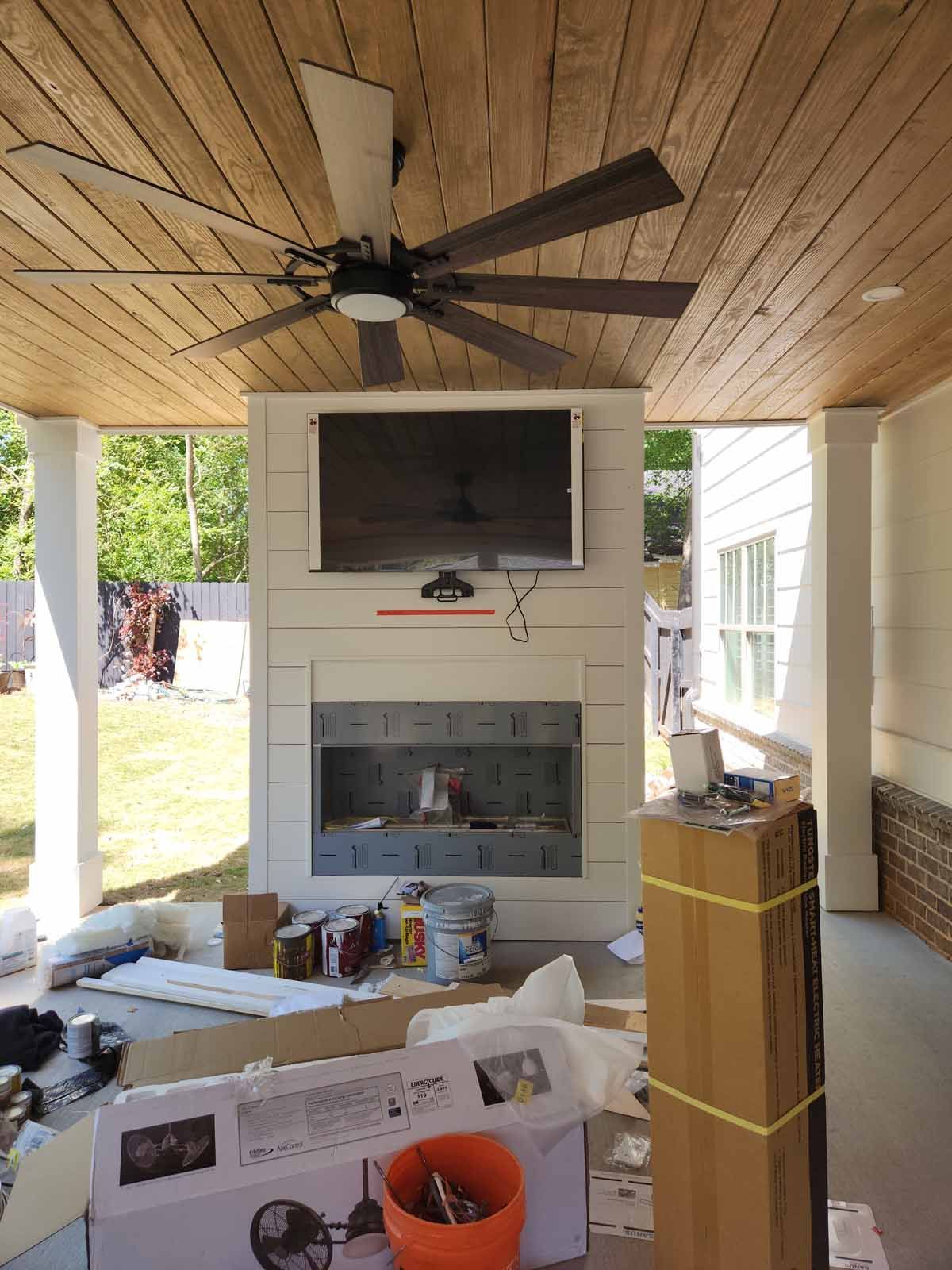 A ceiling fan is hanging from the ceiling above a fireplace.