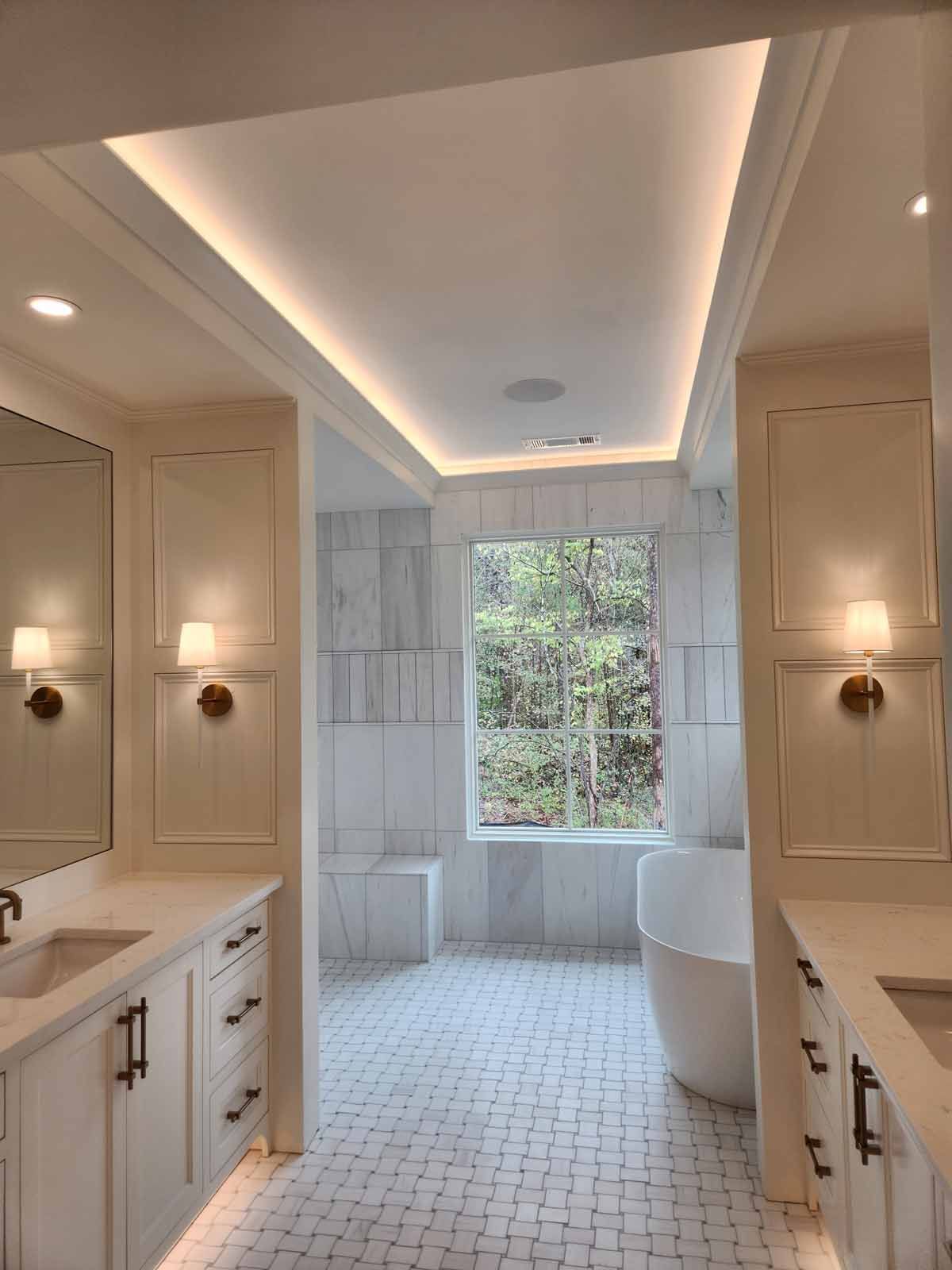 A bathroom with two sinks , a tub , a mirror and a window.
