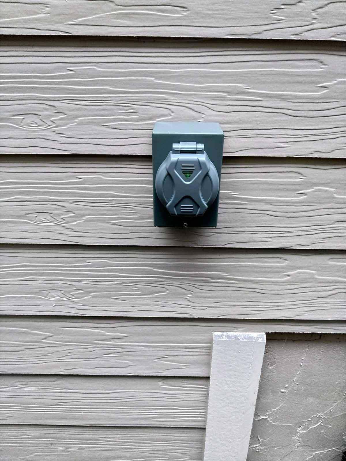 A close up of a electrical outlet on the side of a house.