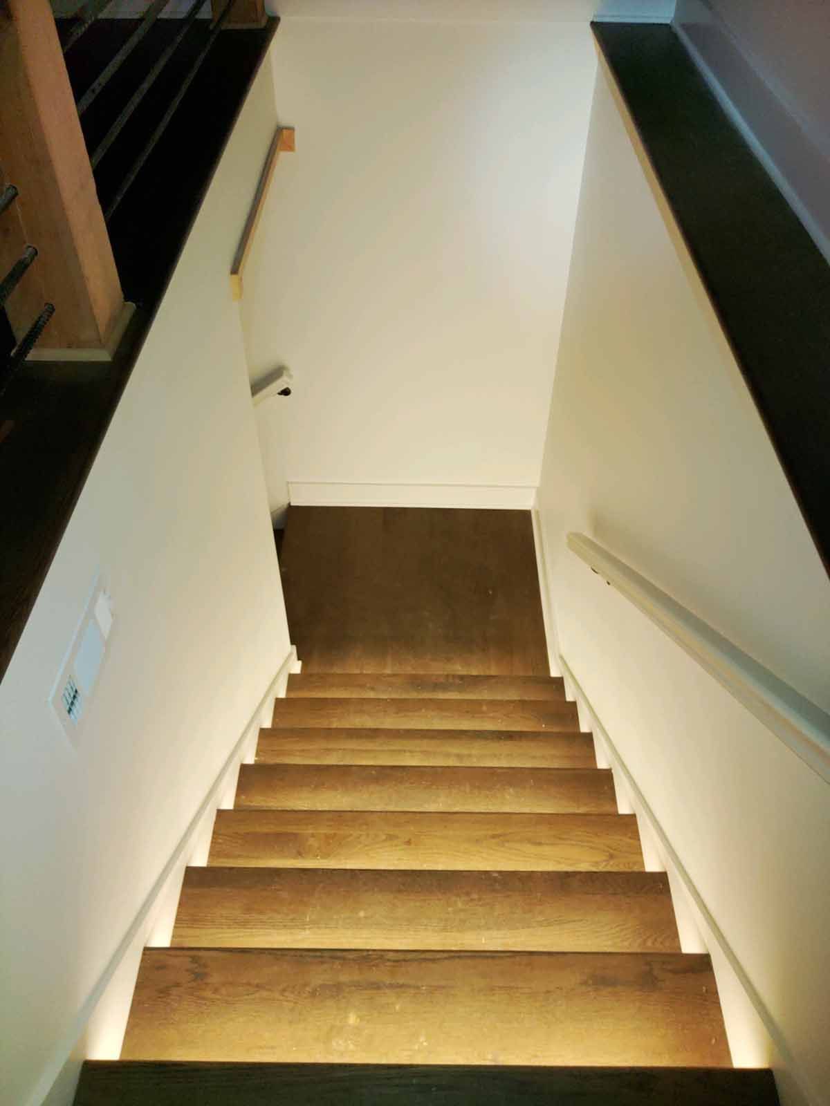 A set of wooden stairs leading up to a white wall