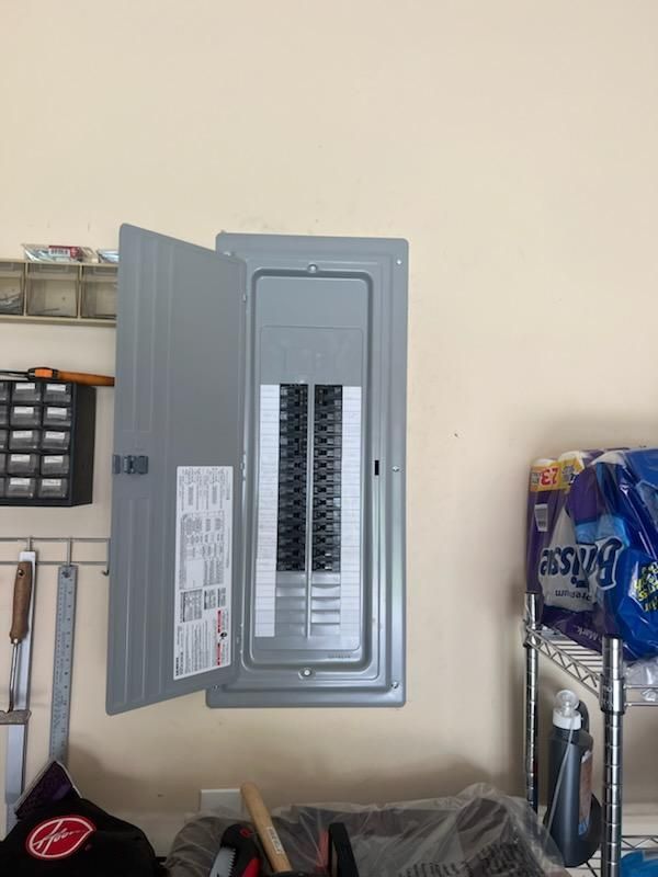 An open electrical box in a garage next to a bag of frosty