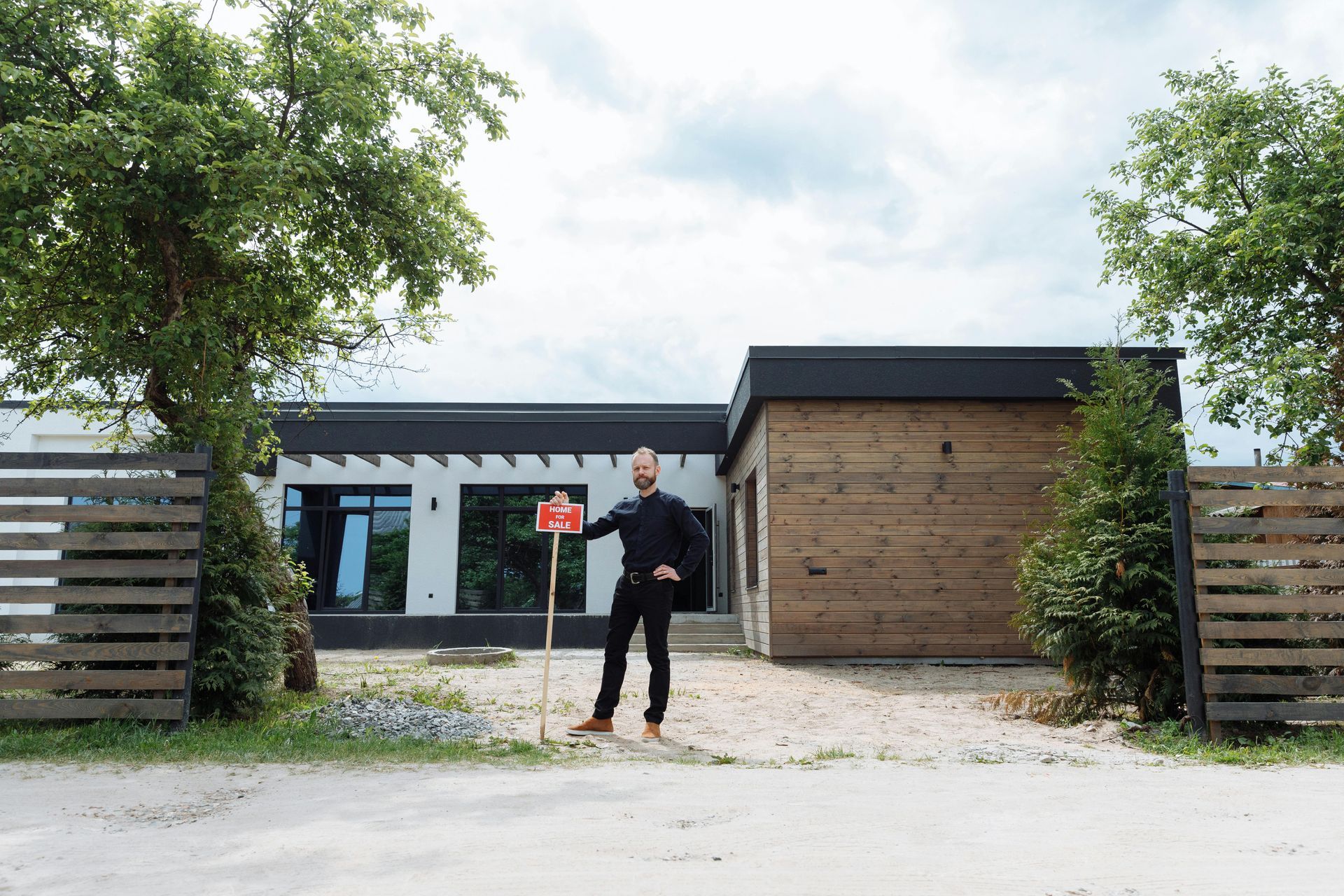 Someone standing in front a house for sale