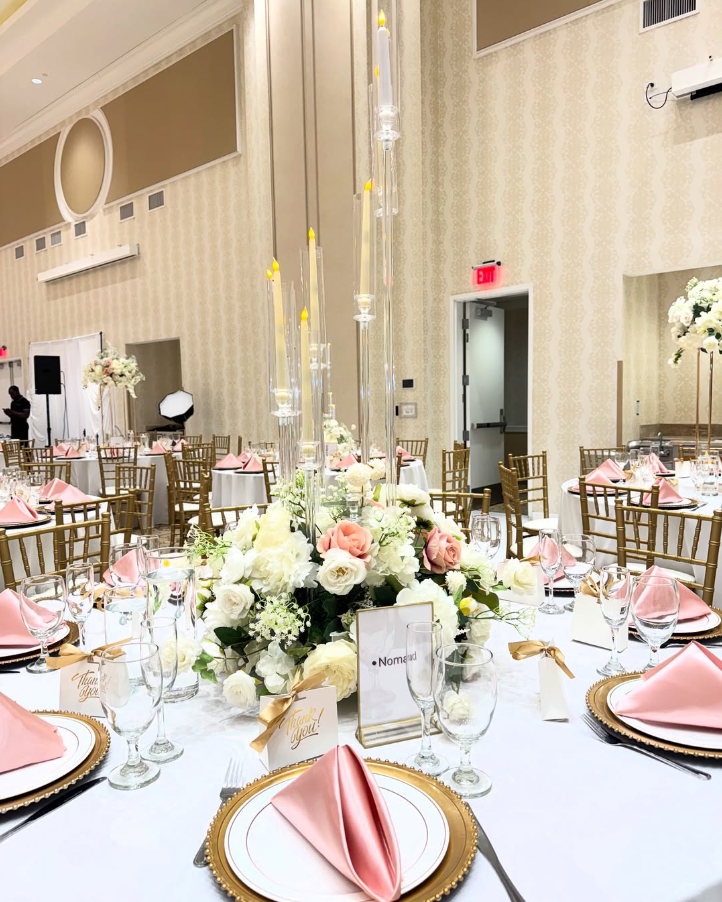 A large room with tables and chairs set up for a wedding reception.